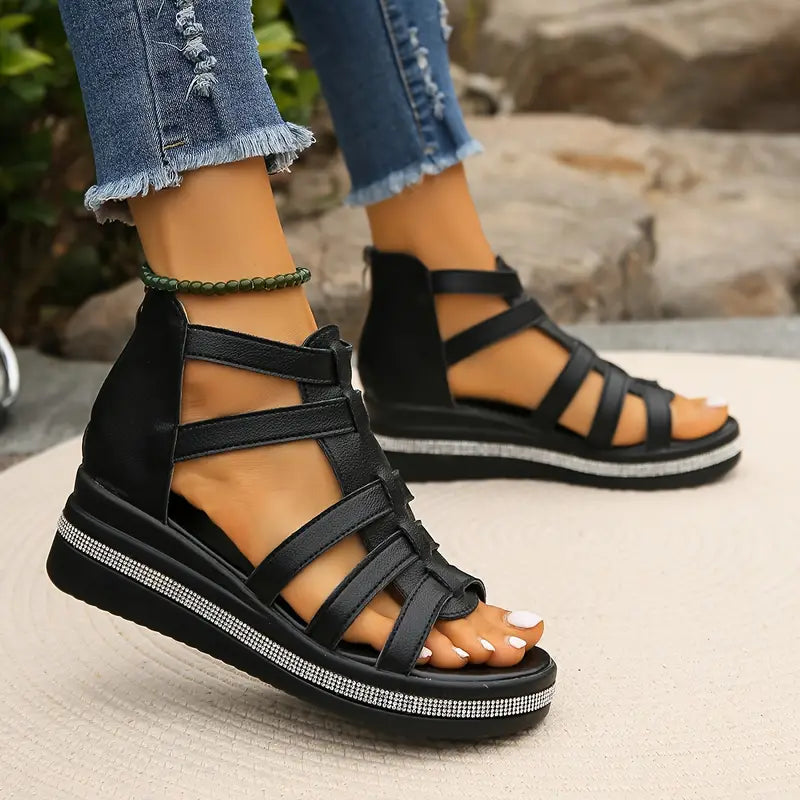 Black gladiator-style cutout wedge sandals with crisscross straps and rhinestone trim
