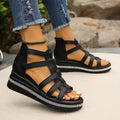 Black gladiator-style cutout wedge sandals with crisscross straps and rhinestone trim