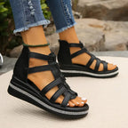 Black gladiator-style cutout wedge sandals with crisscross straps and rhinestone trim