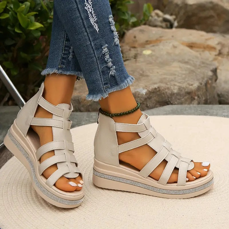 Beige gladiator-style cutout wedge sandals with crisscross straps and rhinestone trim