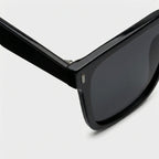 Oversized square sunglasses, black frame with dark lens and small metal detail