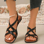 Black square-toe flat sandals with criss-cross straps and cushioned footbed.