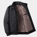 Black quilted fall jacket with front zipper and tan sherpa lining, ribbed cuffs