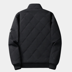Black quilted jacket back view with stand collar and ribbed hem, zipper