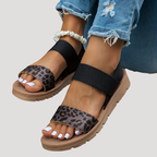 Black flat sandals with cross strap, leopard print toe band and open toes