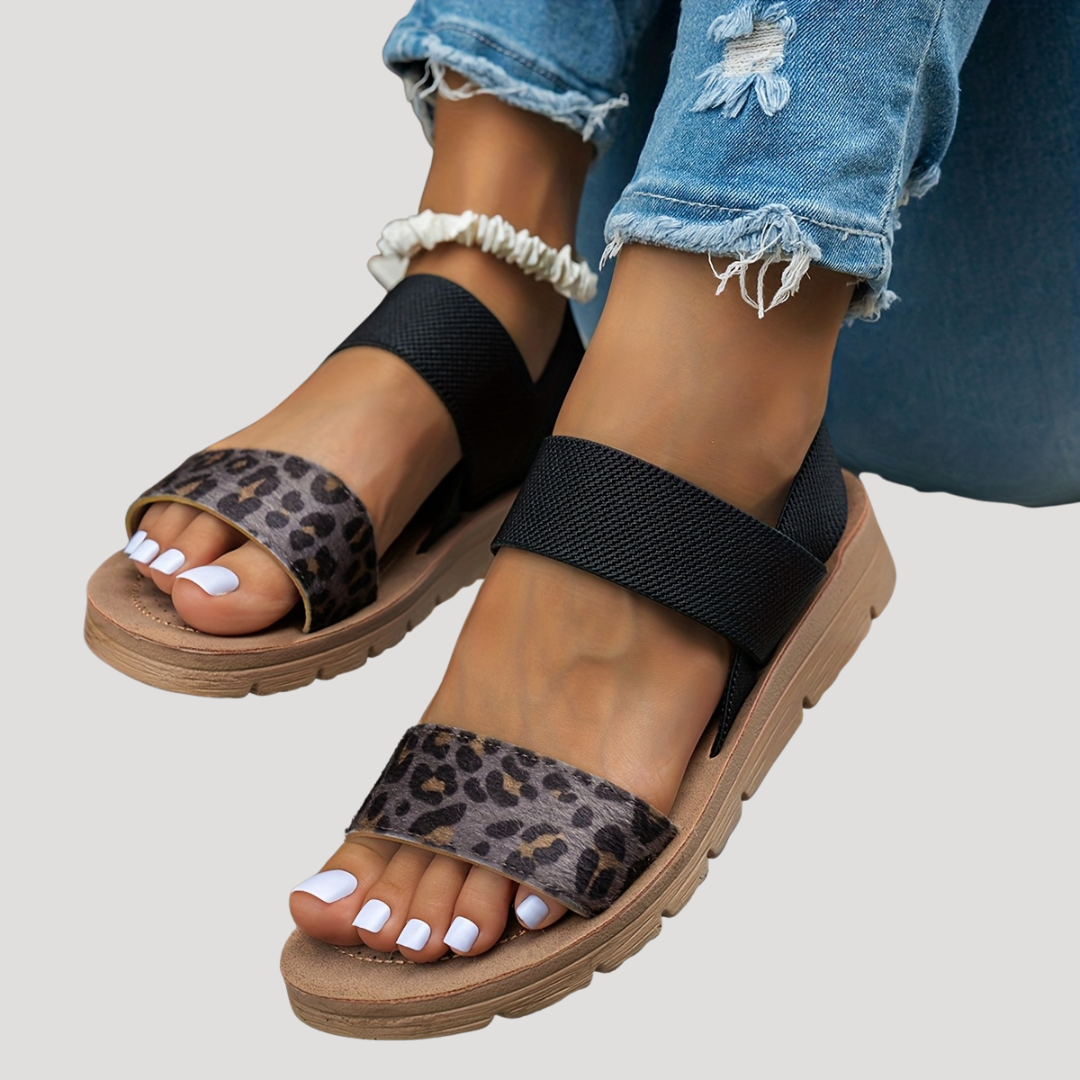 Black flat sandals with cross strap, leopard print toe band and open toes