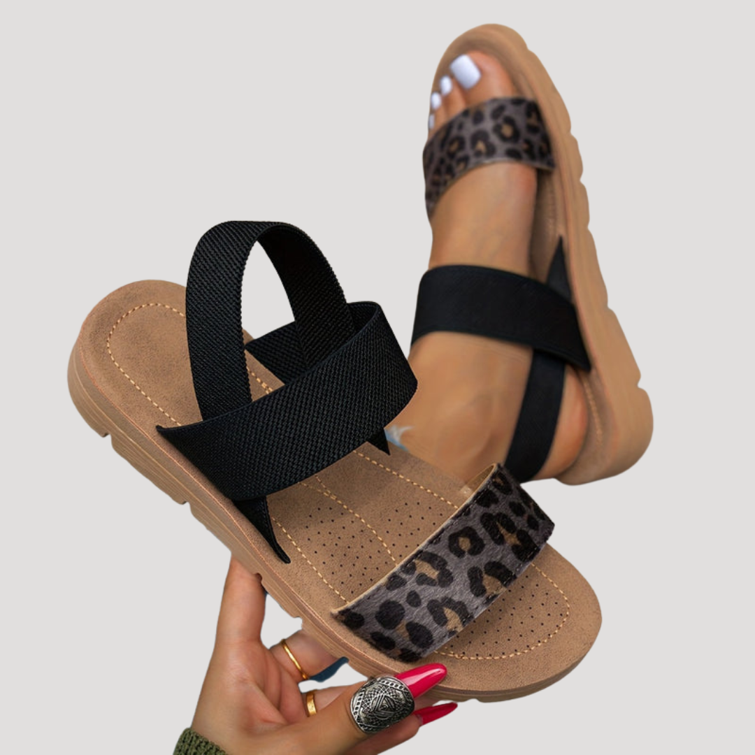 Black cross-strap flat sandals with leopard print toe band and open toes