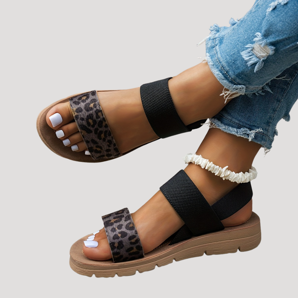 Black flat sandals with cross strap and leopard print toe band, open-toe design