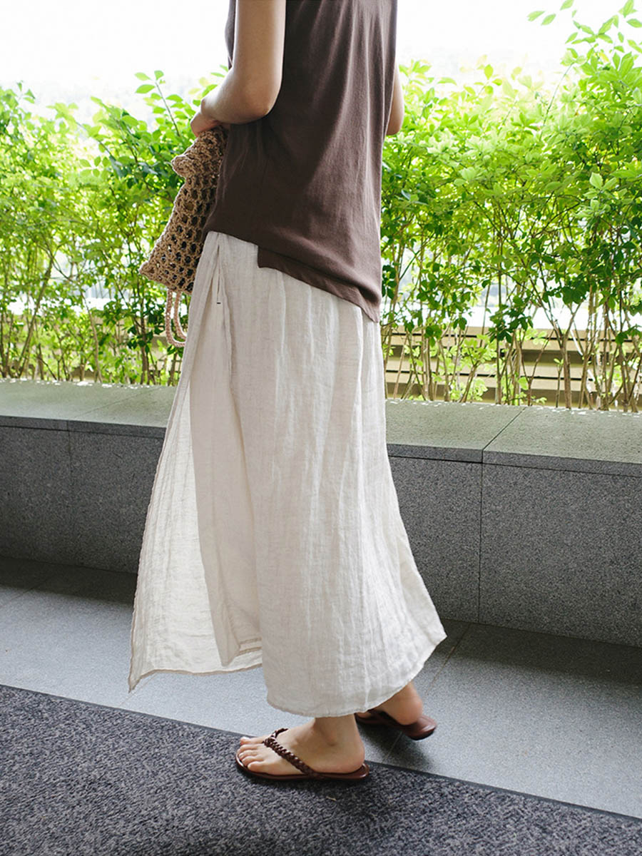 Cream linen culottes with loose wide legs, elastic waist, and side pockets