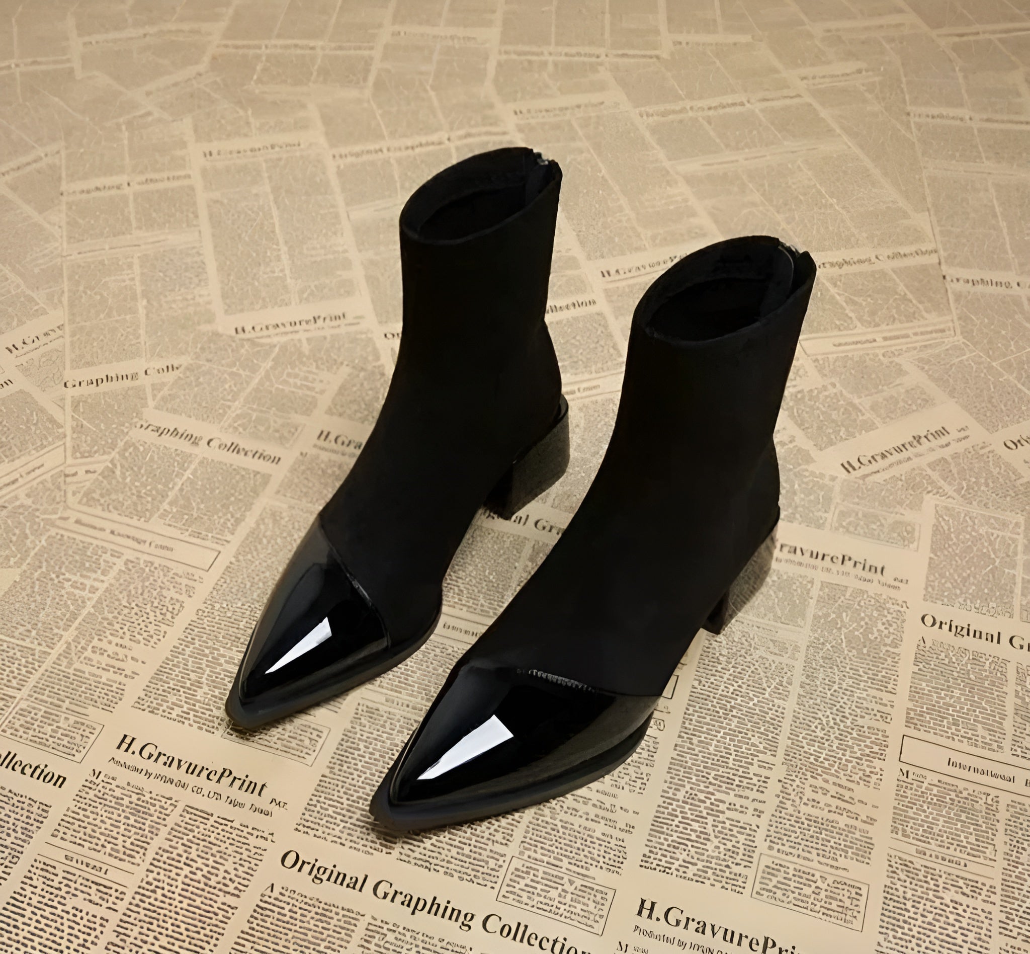 Black suede ankle boots pair with glossy pointed toe and block heel, side zipper