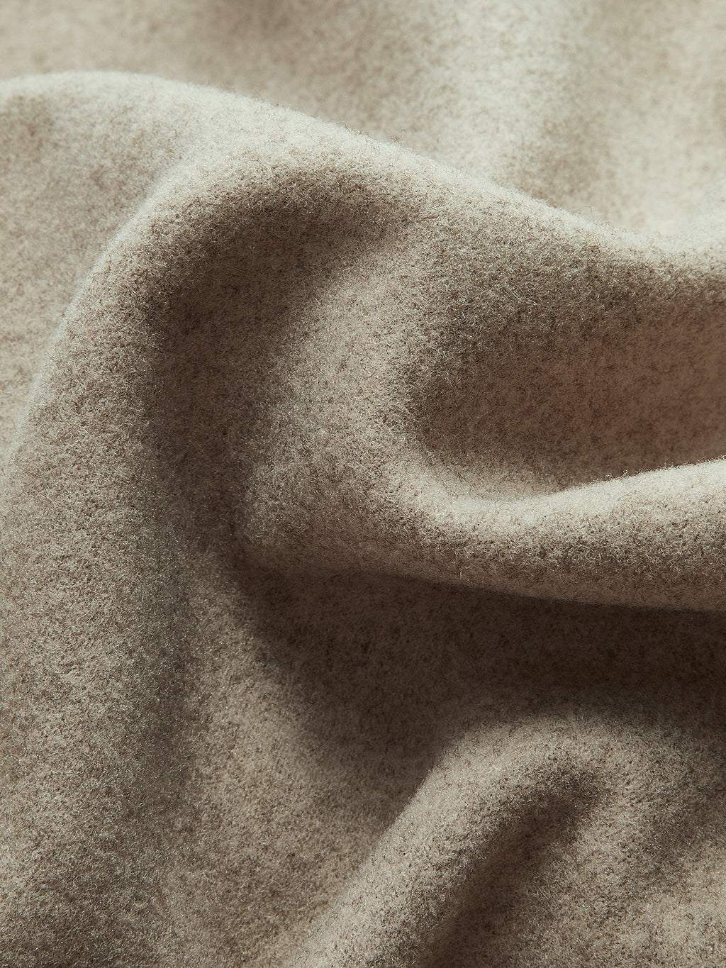 Taupe textured wool-like fabric detail on a double-breasted pea coat