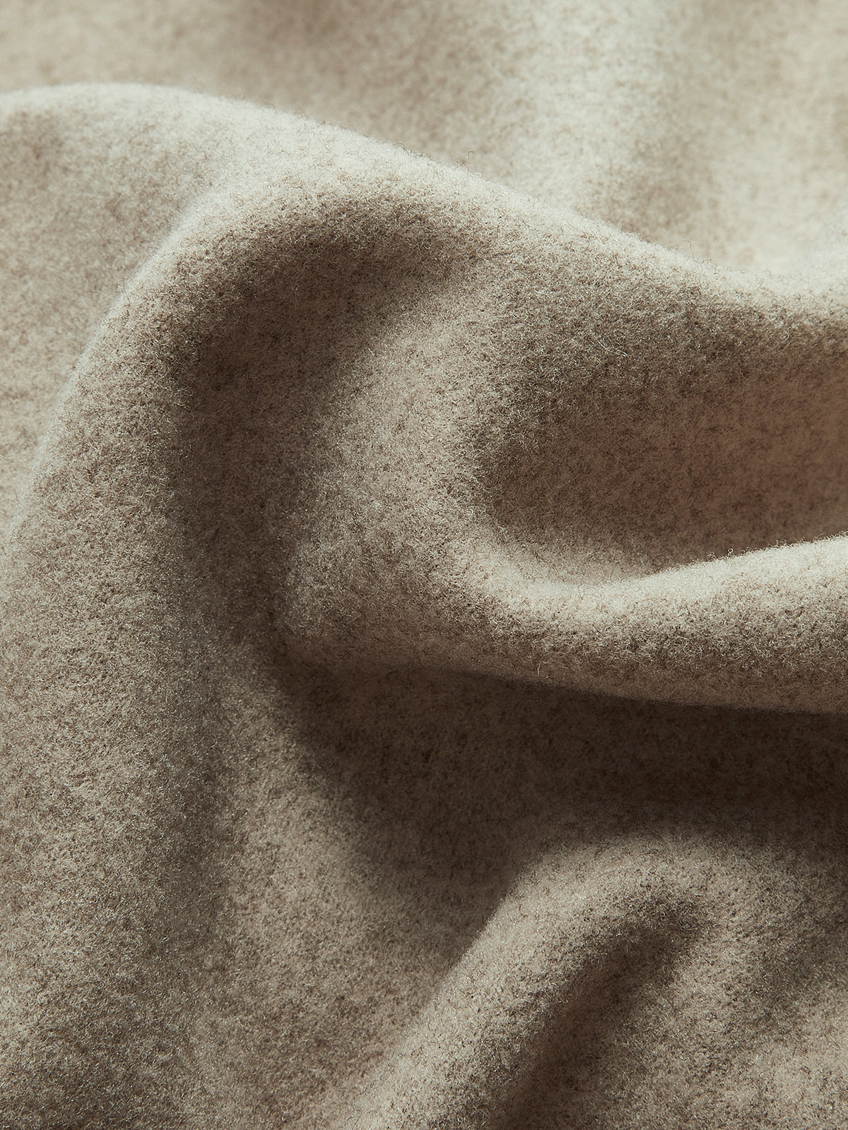 Taupe textured wool-like fabric detail on a double-breasted pea coat