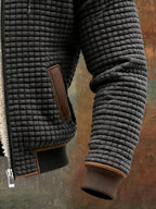 Black quilted insulated fleece jacket sleeve and pocket detail with brown leather trim