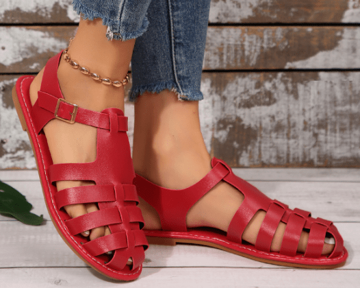 Red leather gladiator sandals with ankle strap and buckle, flat open-toe design