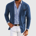 Men's blue blazer with notch lapels, chest pocket holding a pen, side pockets.