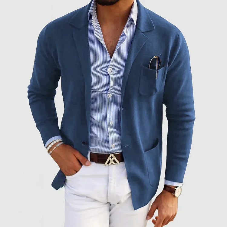 Men's blue blazer with notch lapels, chest pocket holding a pen, side pockets.