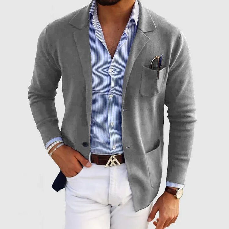 Men's light gray blazer with notch lapels, chest pocket holding a pen, side pockets.