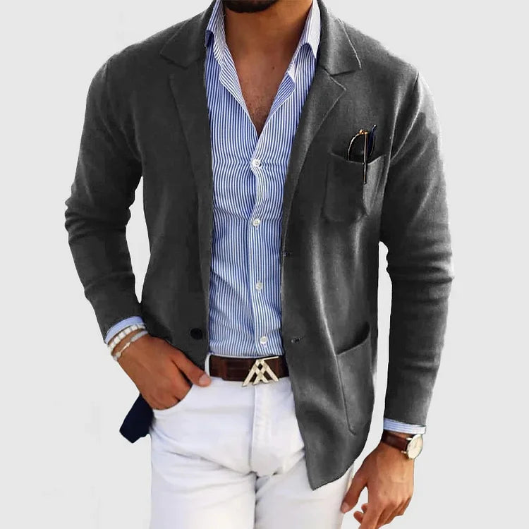 Men's dark gray blazer with notch lapels, chest pocket holding a pen, side pockets.