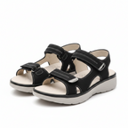 Women's black open-toe slide sandals with adjustable buckled straps and cushioned footbed