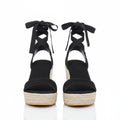 Black lace-up wedge sandals with crisscross ankle straps, peep-toe platform