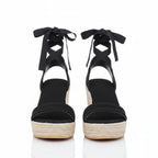 Black lace-up wedge sandals with crisscross ankle straps, peep-toe platform