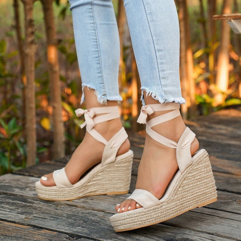 Beige espadrille wedge sandals with ribbon ankle ties and peep-toe, side view