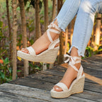 Beige espadrille wedge sandals with bow-tie ankle straps and open toe