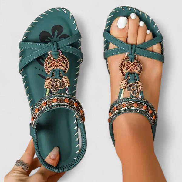 Teal-green orthopedic cushioned strap sandals with ankle straps and ornate hanging charms