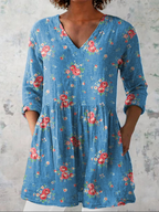 Blue floral V-neck long blouse with drapey relaxed fit and three-quarter sleeves.
