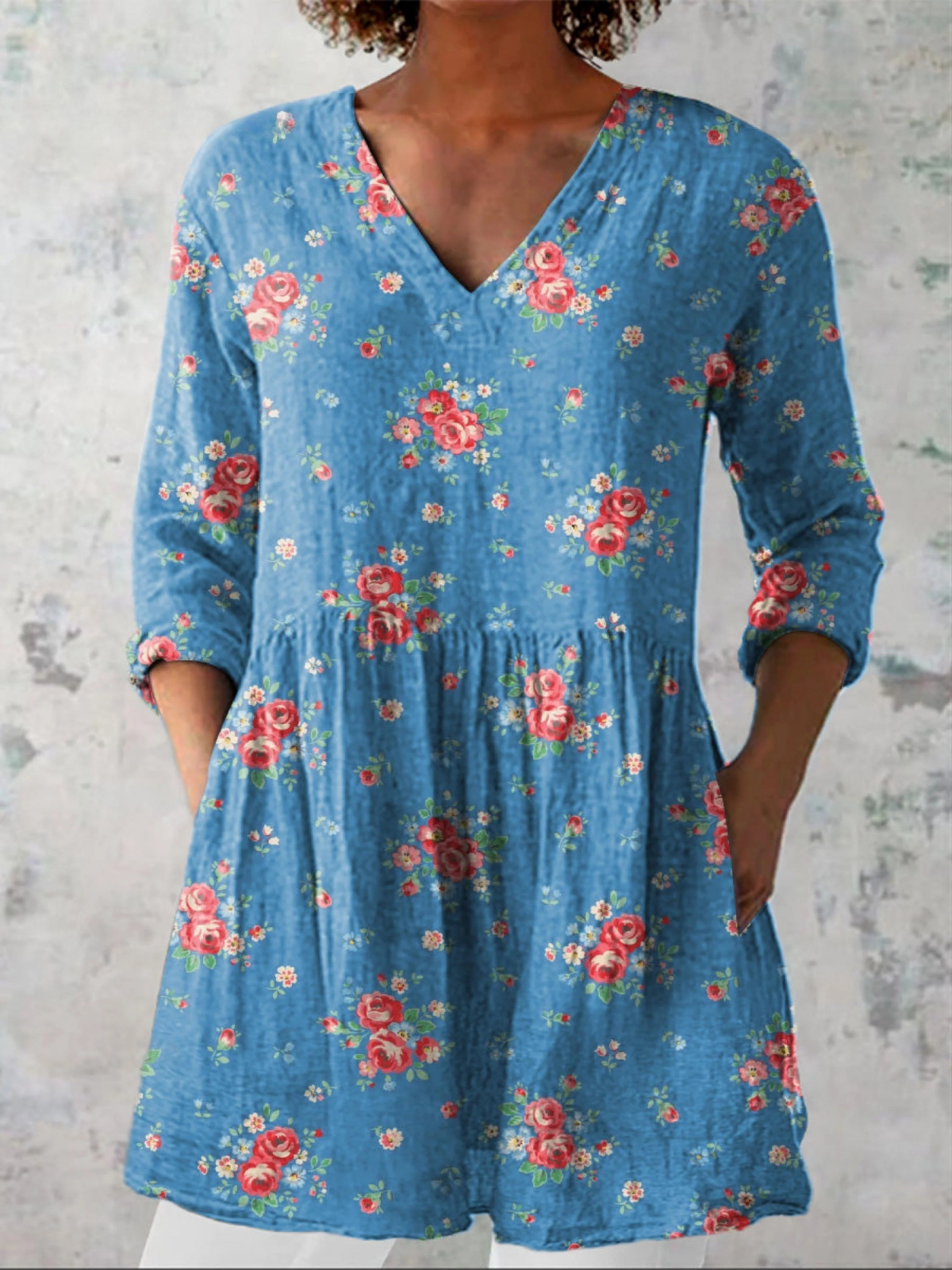Blue floral V-neck long blouse with drapey relaxed fit and three-quarter sleeves.