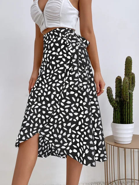 Women's black midi wrap skirt with asymmetrical hem, white allover leaf print