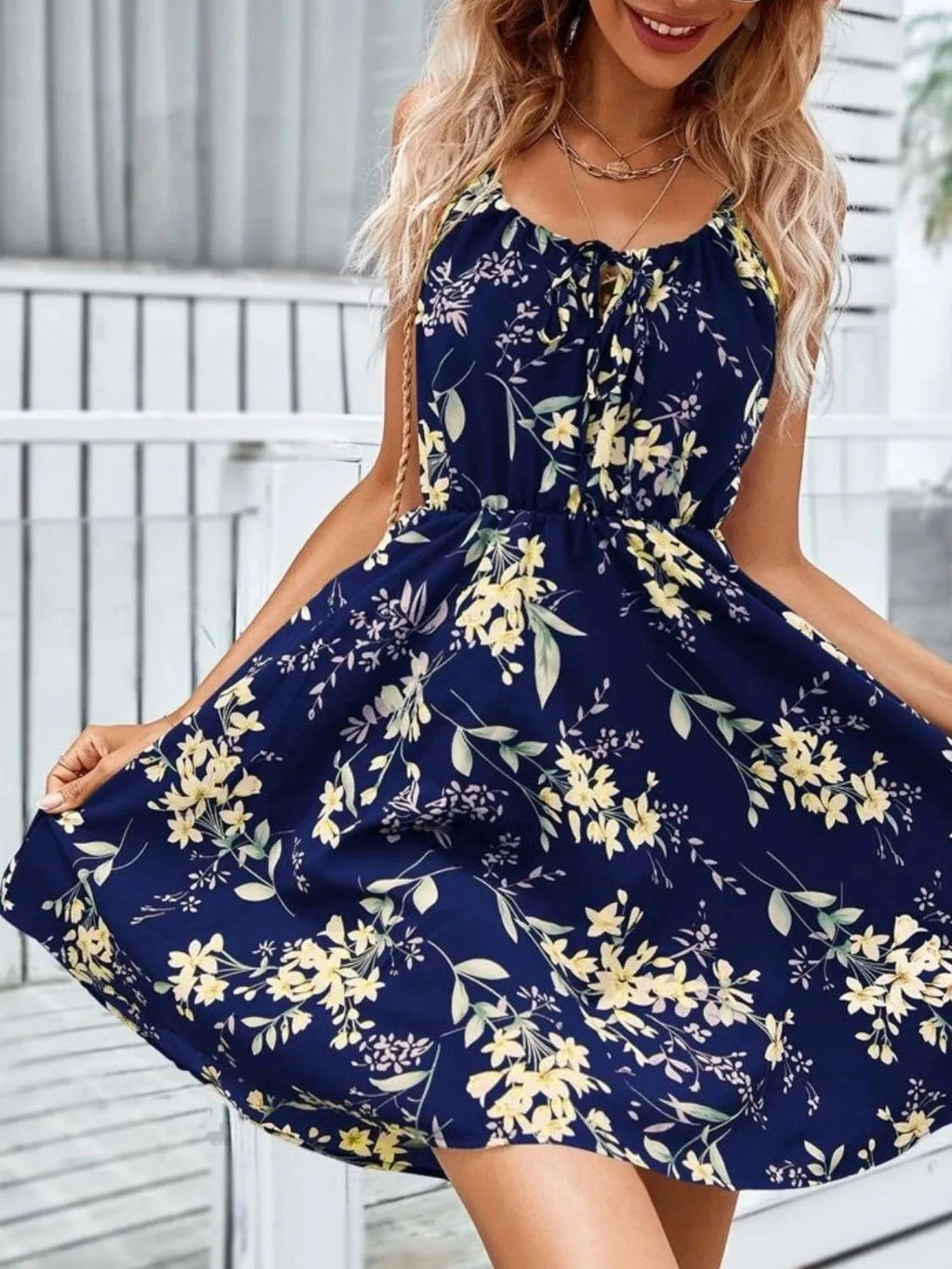 Women’s dark blue mini dress with thin straps and yellow and white floral pattern