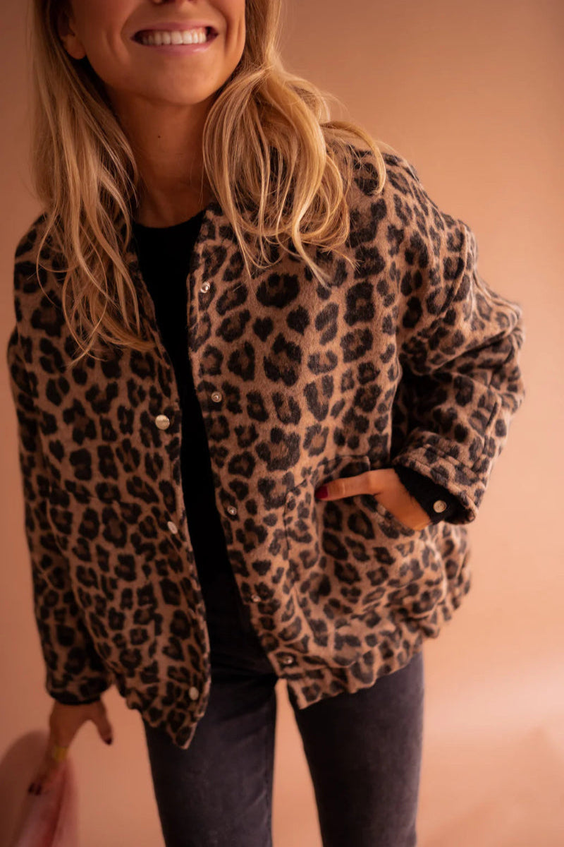 Leopard-print bomber jacket close-up: brown with black spots, snap-button placket
