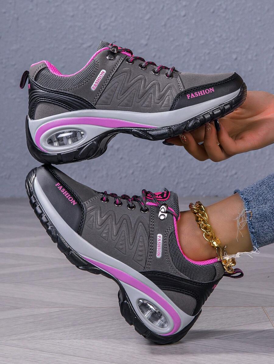 Men’s hiking shoe in dark gray/black with pink accents, lace-up, air-cushioned sole.