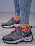 Men’s hiking shoe in dark gray/black with pink laces, purple trim, padded sole.