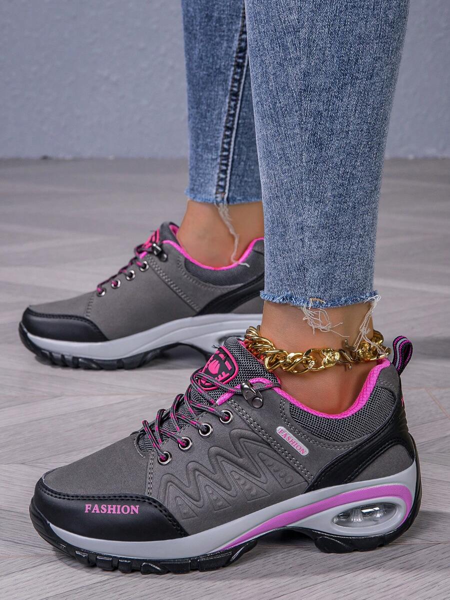 Men’s hiking shoe in dark gray/black with pink laces, purple trim, padded sole.