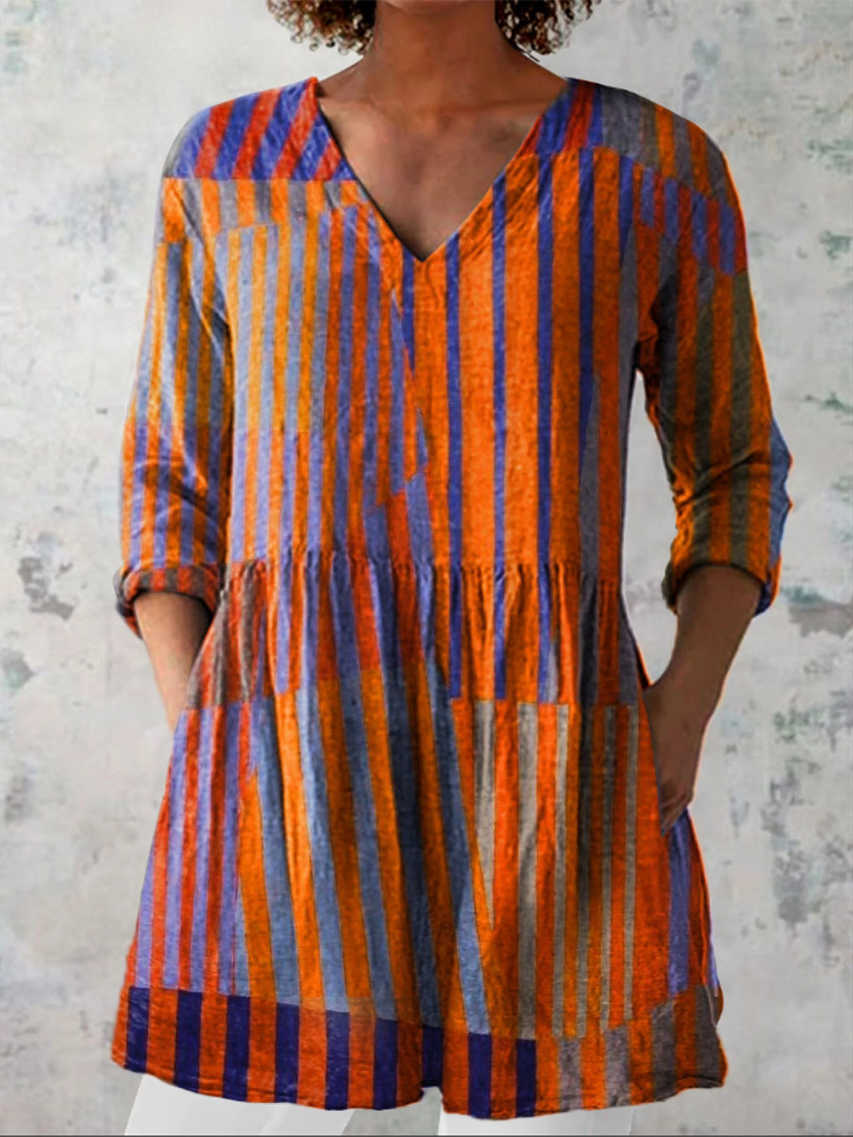 Long V-neck blouse with vertical orange and blue stripes, 3/4 sleeves, gathered waist