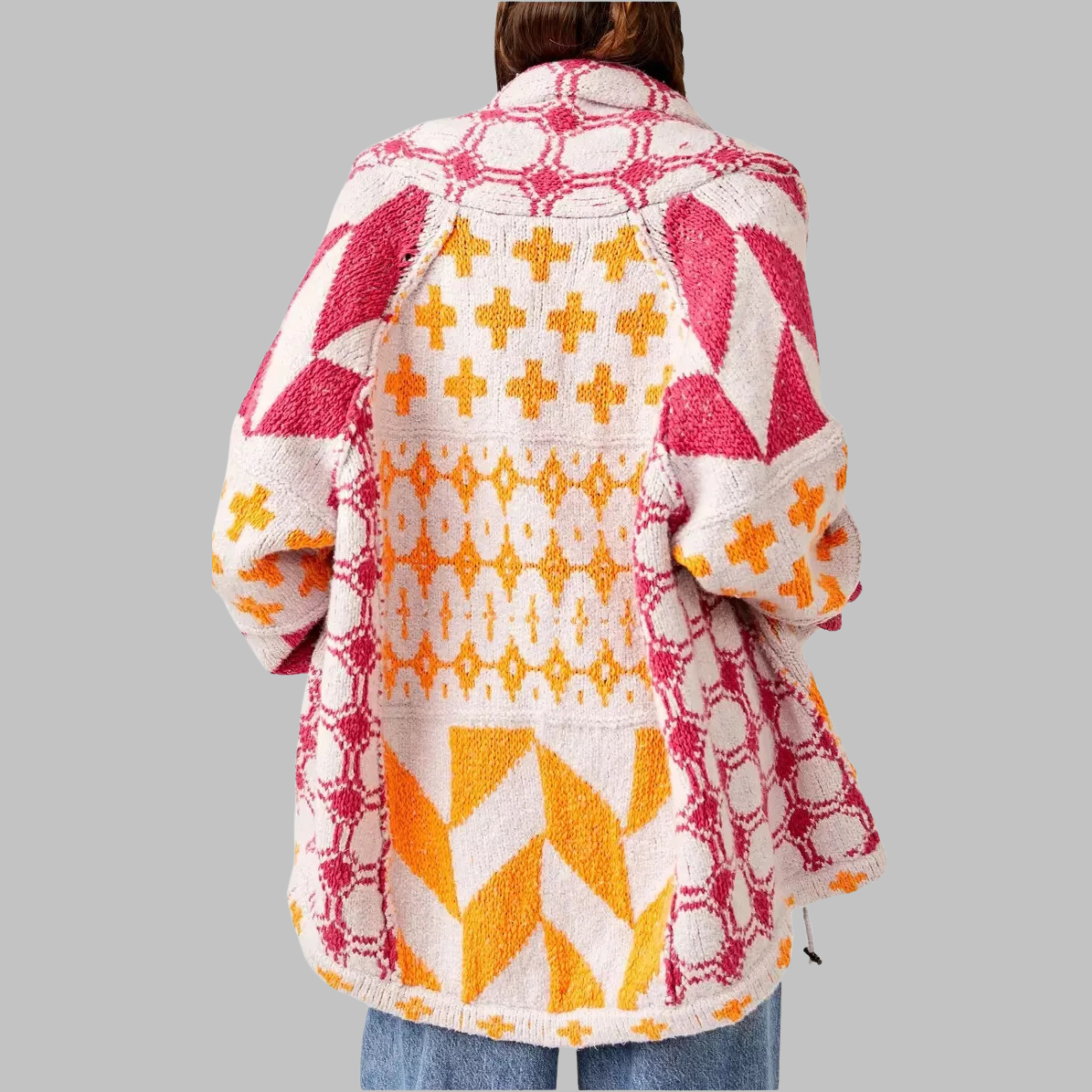 Pink and white oversized knit cardigan with patterned back and multicolor motifs.