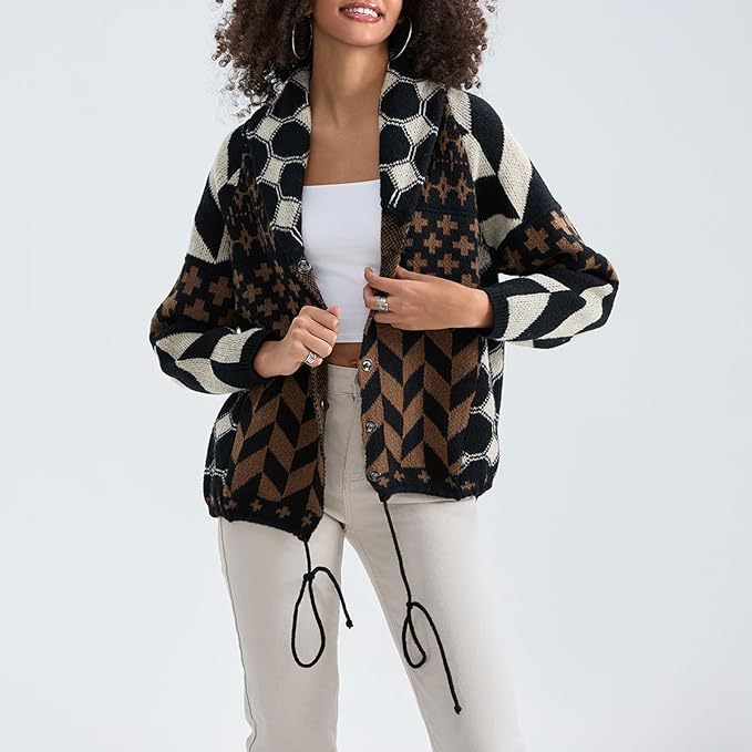Black oversized knit cardigan with cream geometric panels and cross-stitch motifs.