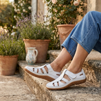 Women’s white slip-on sandals with wide cutout straps and cushioned ergonomic footbed