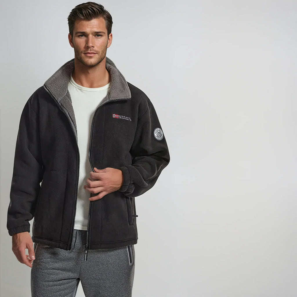 Black premium fleece vest on model, gray collar, full-zip design.