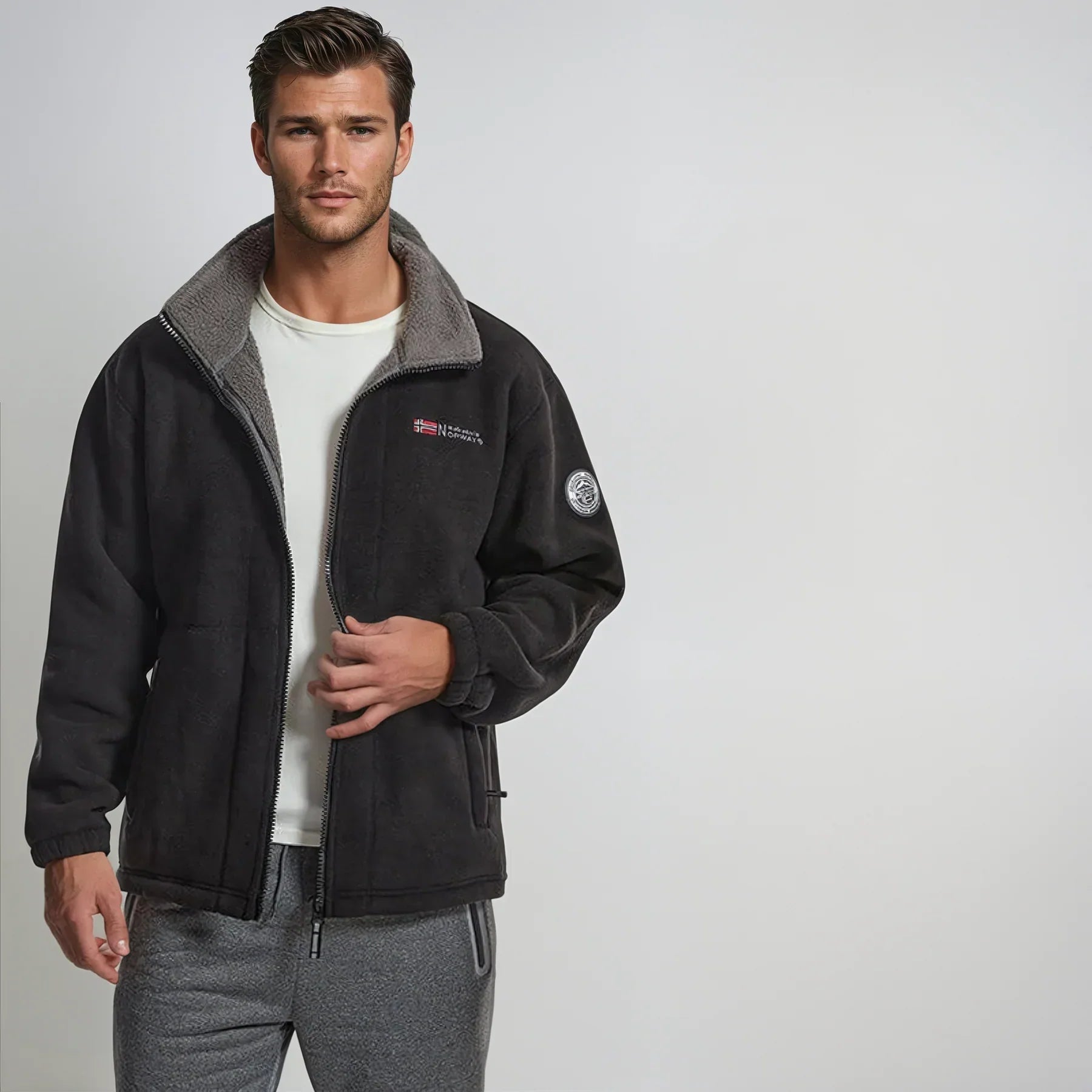 Black premium fleece vest on model, gray collar, full-zip design.