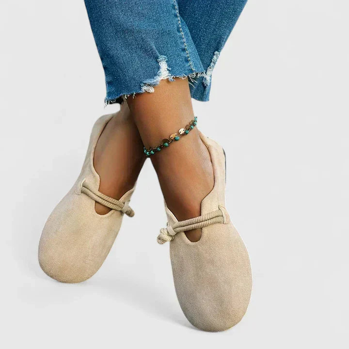 Beige cushioned slip-on loafers with elastic strap, close view on feet