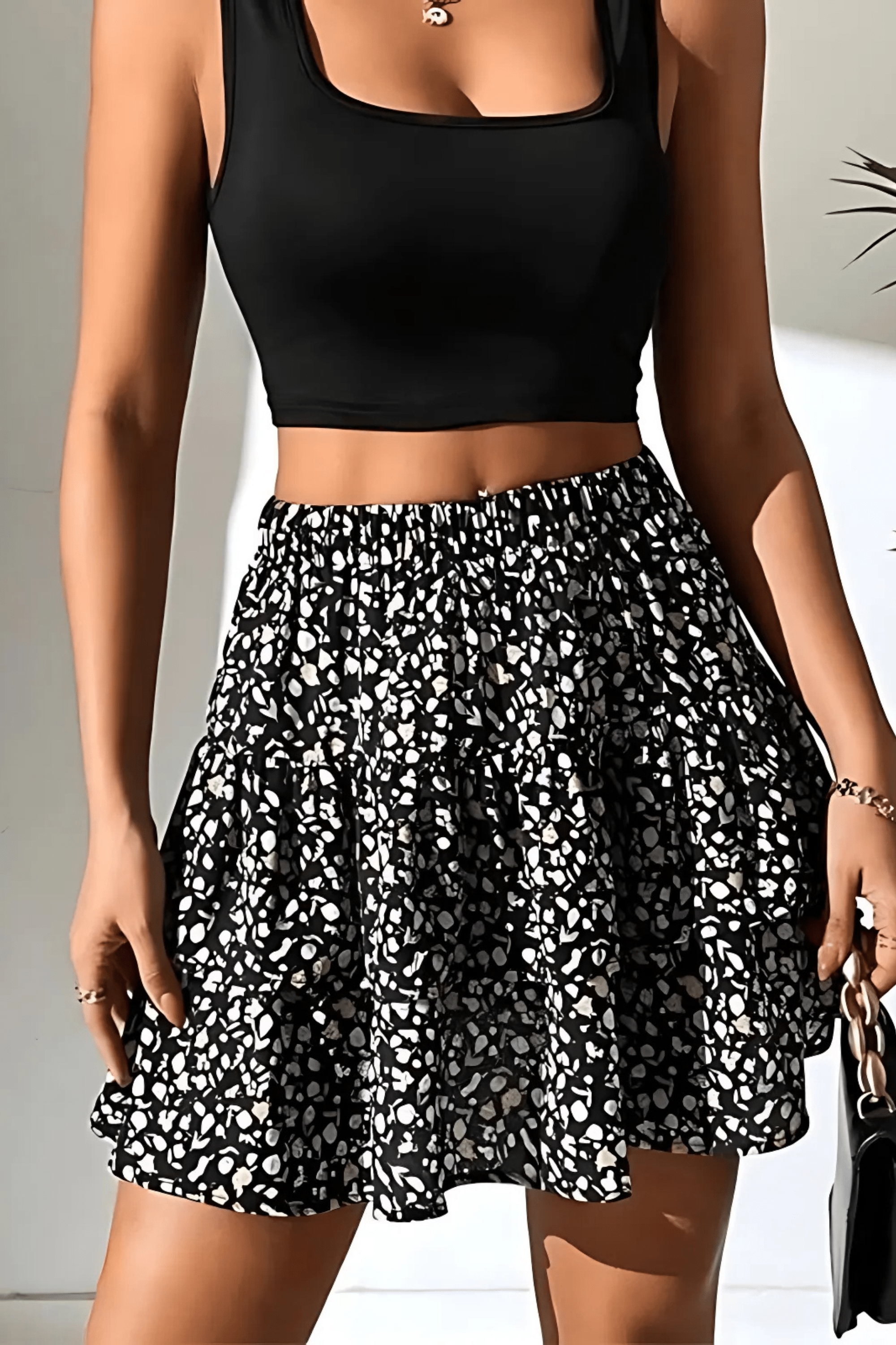 Women's mini skirt with black base and white abstract print tiered ruffles.