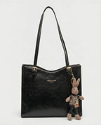 Black vegan leather small crossbody tote bag with top handles and bunny charm keychain.