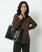 Black small crossbody tote with top handles, front logo, and attached bunny charm keychain.