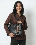 Black vegan leather small tote crossbody bag with front logo and bunny charm keychain.