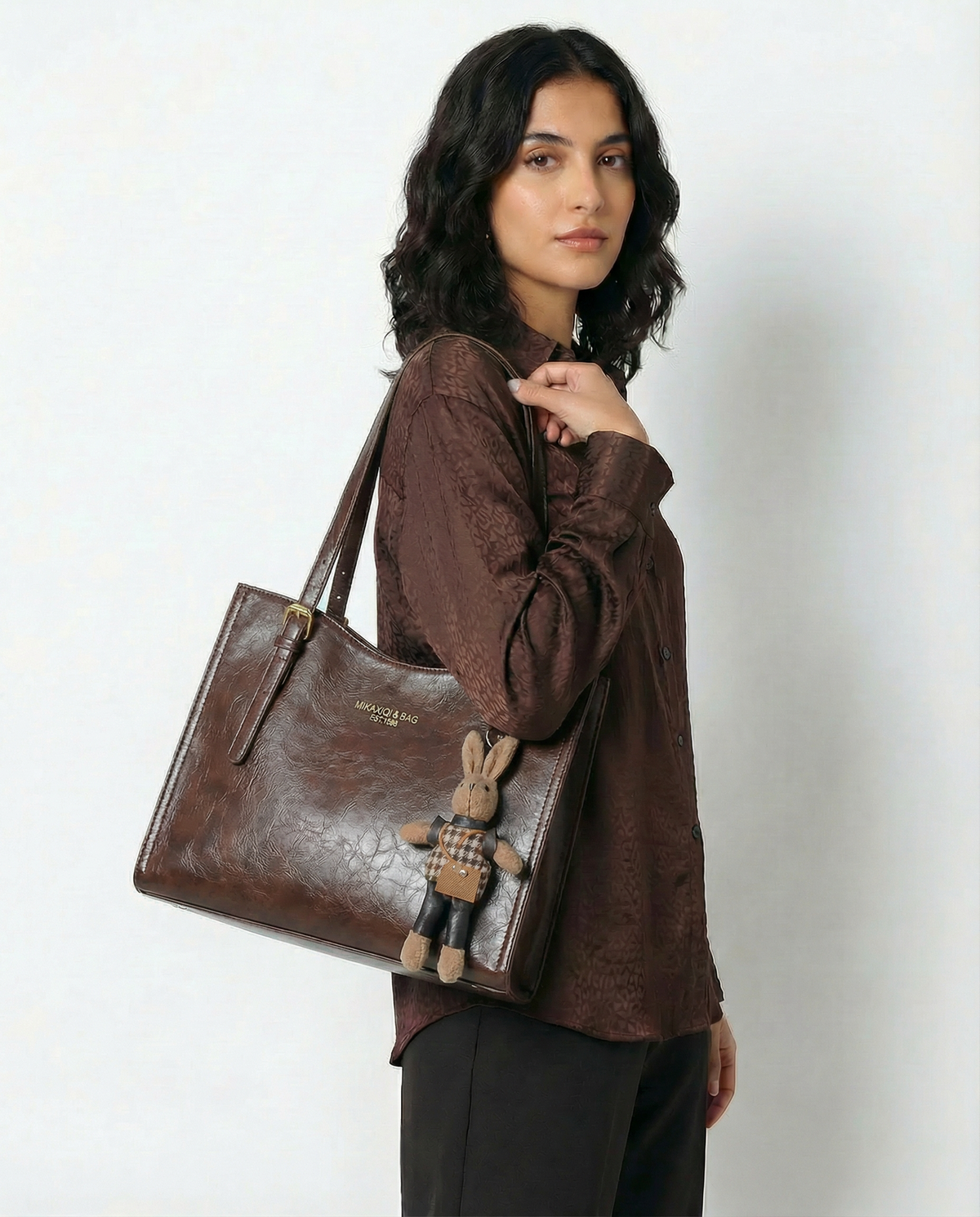 Brown vegan leather small crossbody tote with top handles and bunny charm keychain.