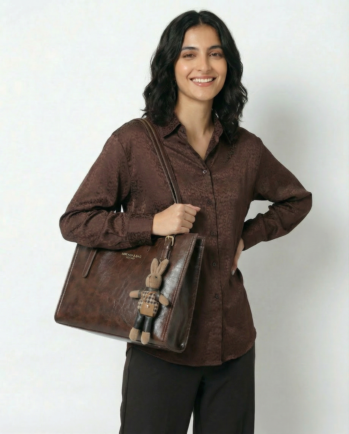 Brown vegan leather small shoulder crossbody tote with front logo and bunny charm keychain.