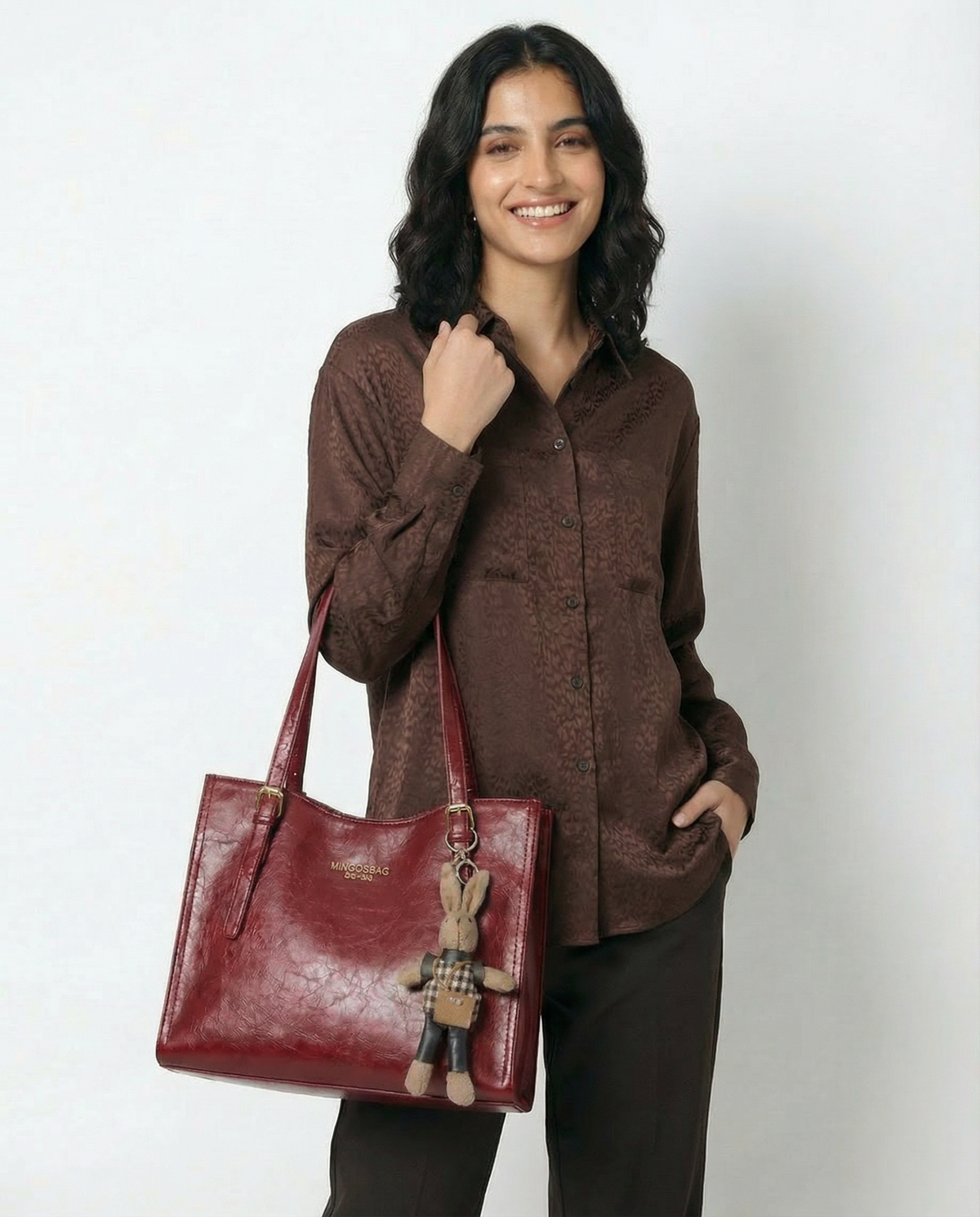 Wine red vegan leather small tote crossbody bag with front logo and bunny charm accessory.
